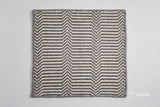 Corner detail of light grey chevron wool rug