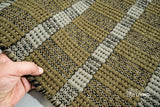 Olive green wool rug under a coffee table in a boho living room