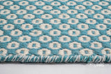 Top-down view of turquoise blue honeycomb geometric rug