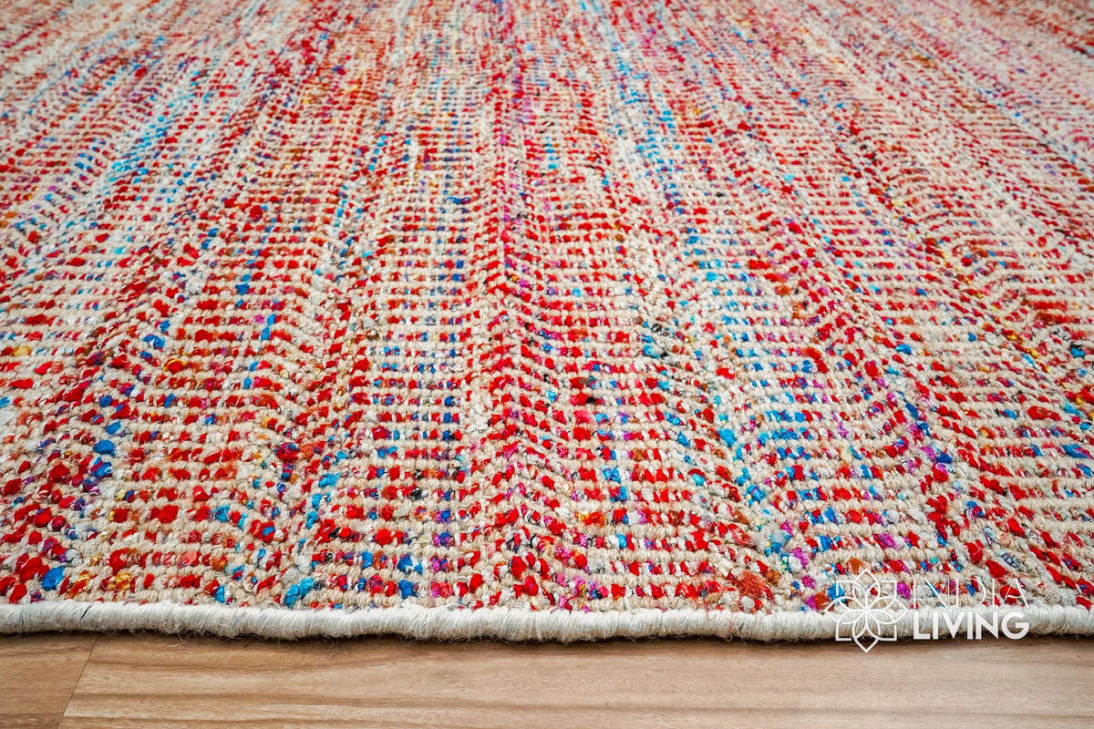 Multi blend red chevron flatweave rug in a bedroom setting