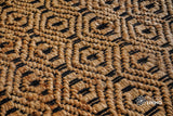 Handwoven jute diamond rug shown in a bedroom setting