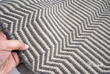Light grey wool rug placed under a coffee table