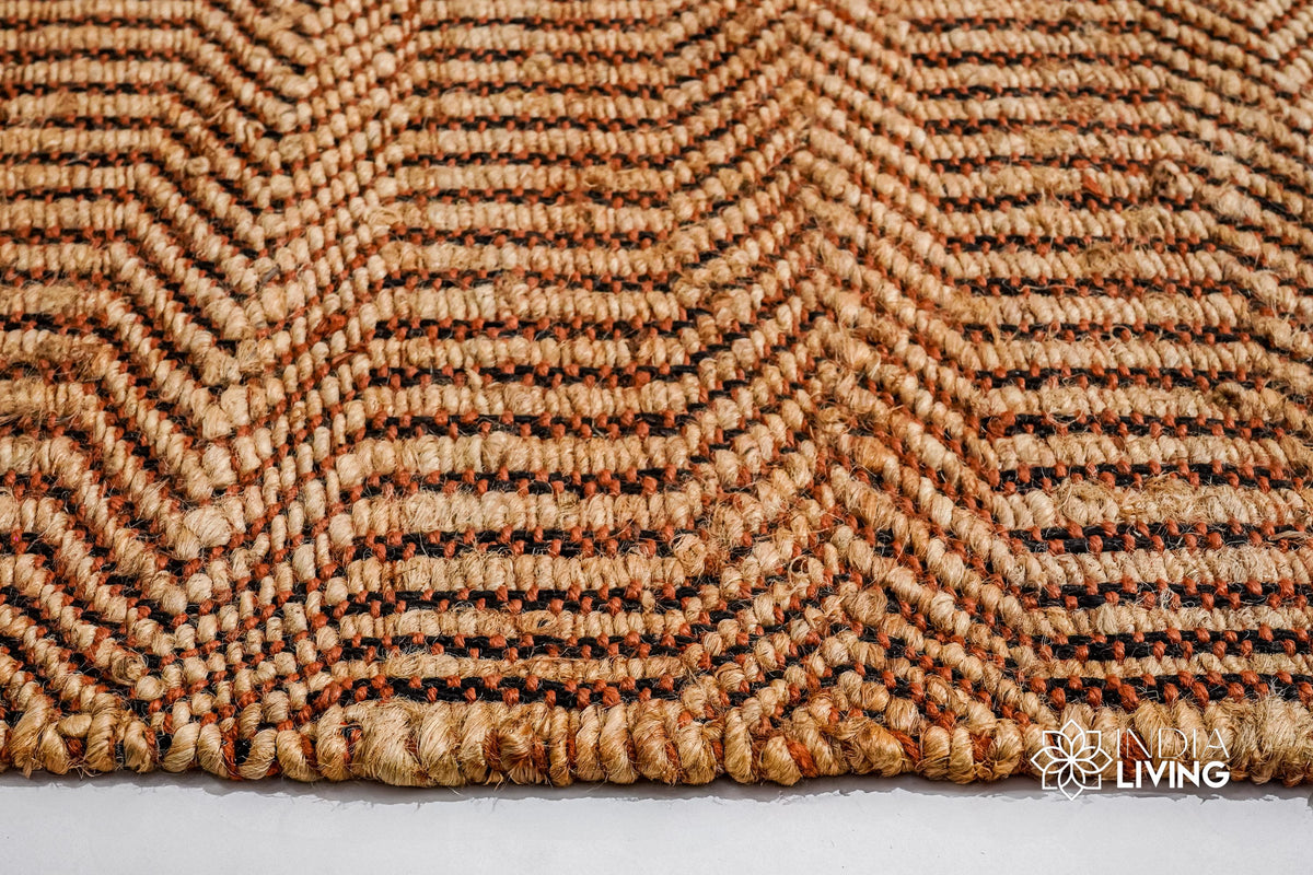 Orange chevron jute rug styled in a boho living room