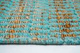 Turquoise geometric flatweave rug in a hallway entryway
