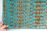 Turquoise blue geometric flatweave rug styled in a living room
