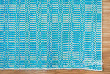 Aqua blue chevron flatweave rug in a coastal-style bedroom
