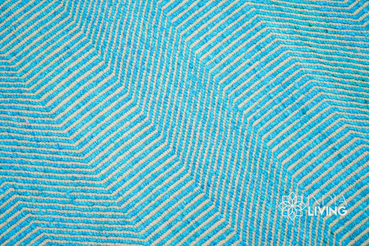 Aqua blue wavy stripe flatweave rug in a coastal-style bedroom