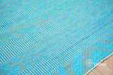Aqua blue wavy stripe wool rug styled in a modern living room