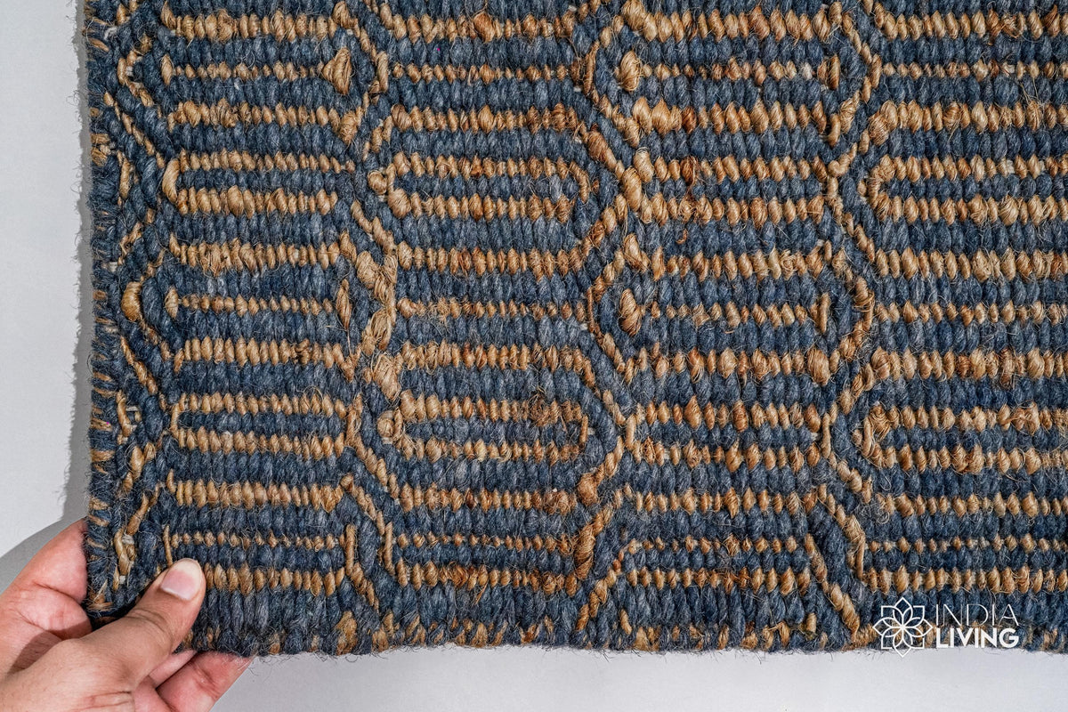 Bluish grey geometric rug corner detail showing edge binding