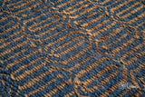 Handwoven geometric weave rug shown in a bedroom setting