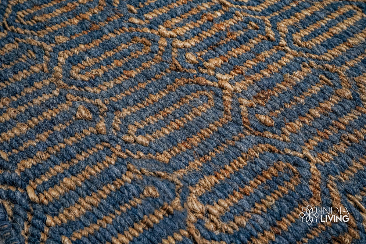 Handwoven geometric weave rug shown in a bedroom setting