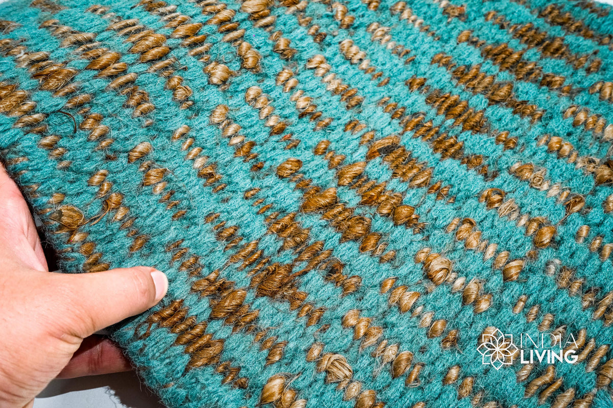 Close-up of ribbed geometric weave texture on turquoise jute wool rug