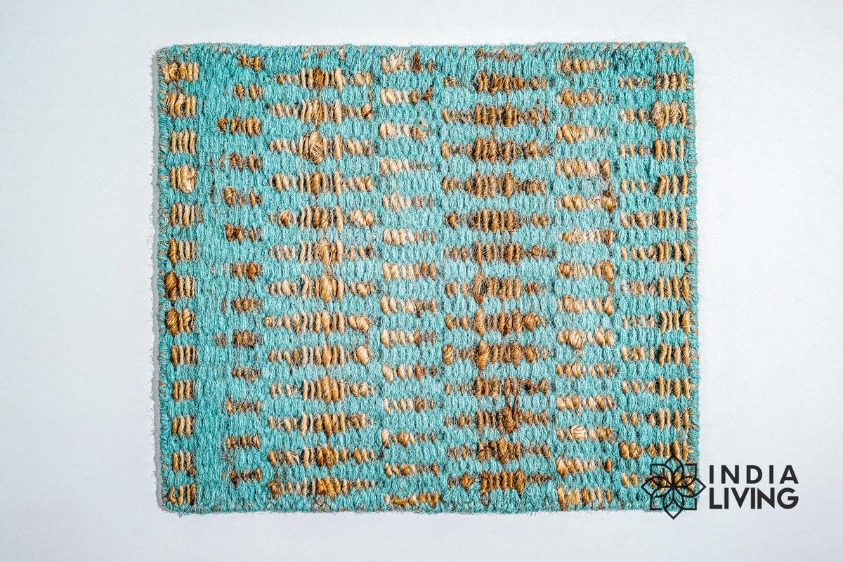 Handwoven turquoise geometric rug shown in a bedroom setting