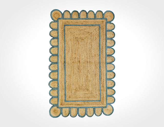 Scalloped jute rug with aqua blue border, flat lay view