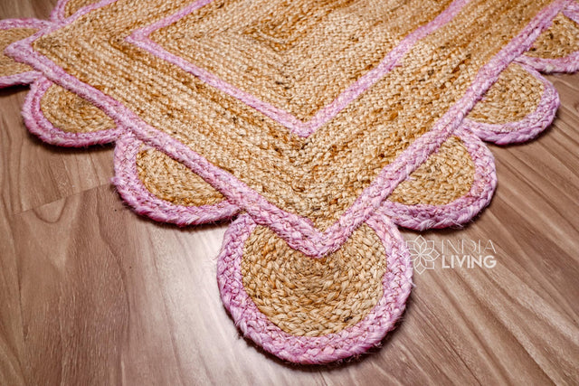 Light pink scalloped jute runner laid flat, full view of hand braided texture