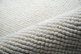 Close-up of ivory wool rug texture