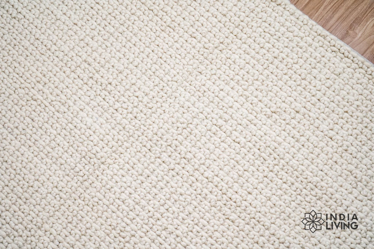 Ivory wool rug placed in a bedroom corner