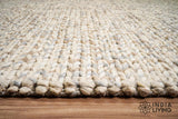 Detail shot of wool fiber texture on taupe grey rug