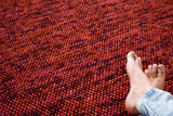 Terracotta wool rug in a bedroom decor setting