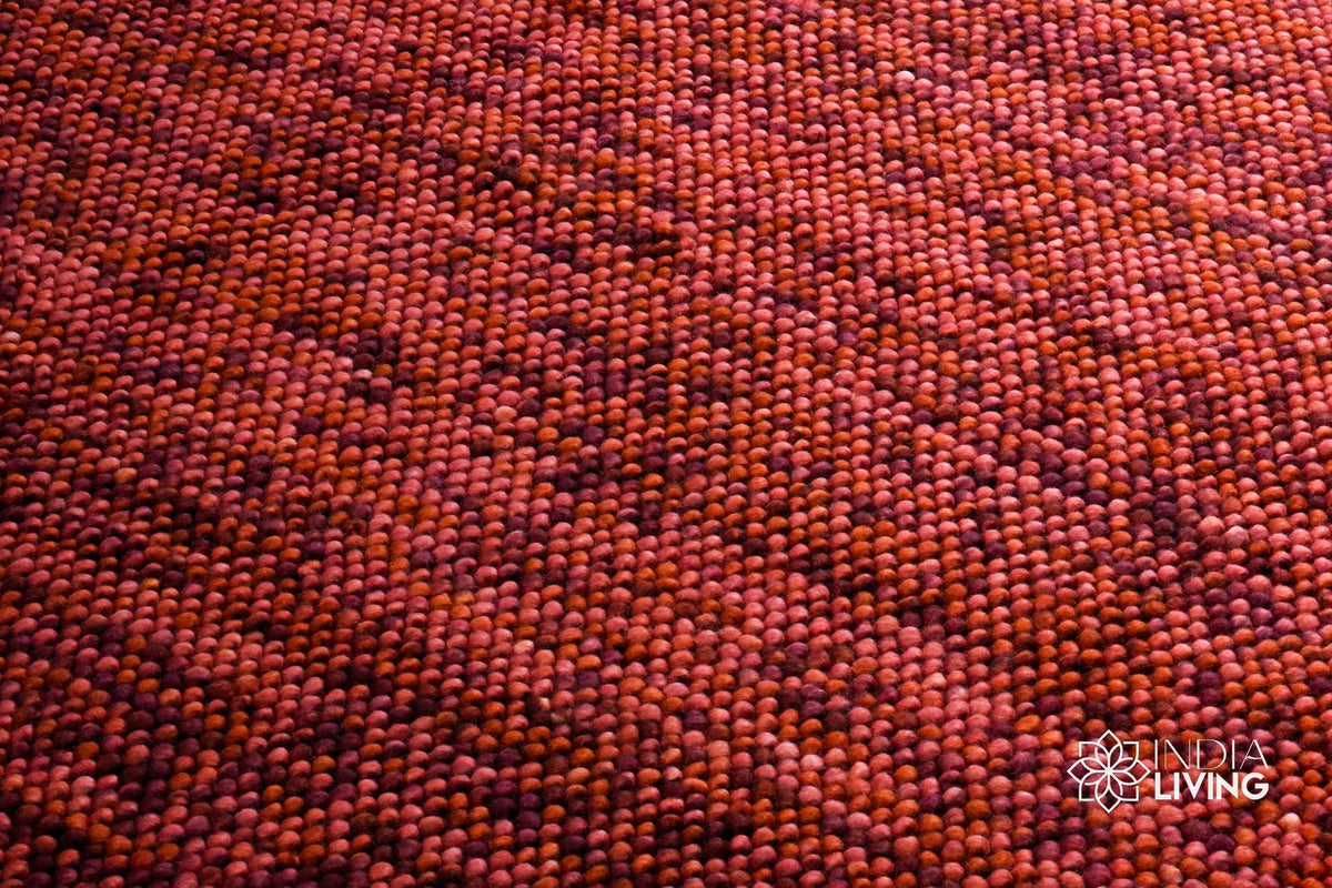 Terracotta wool rug placed under furniture in a living space