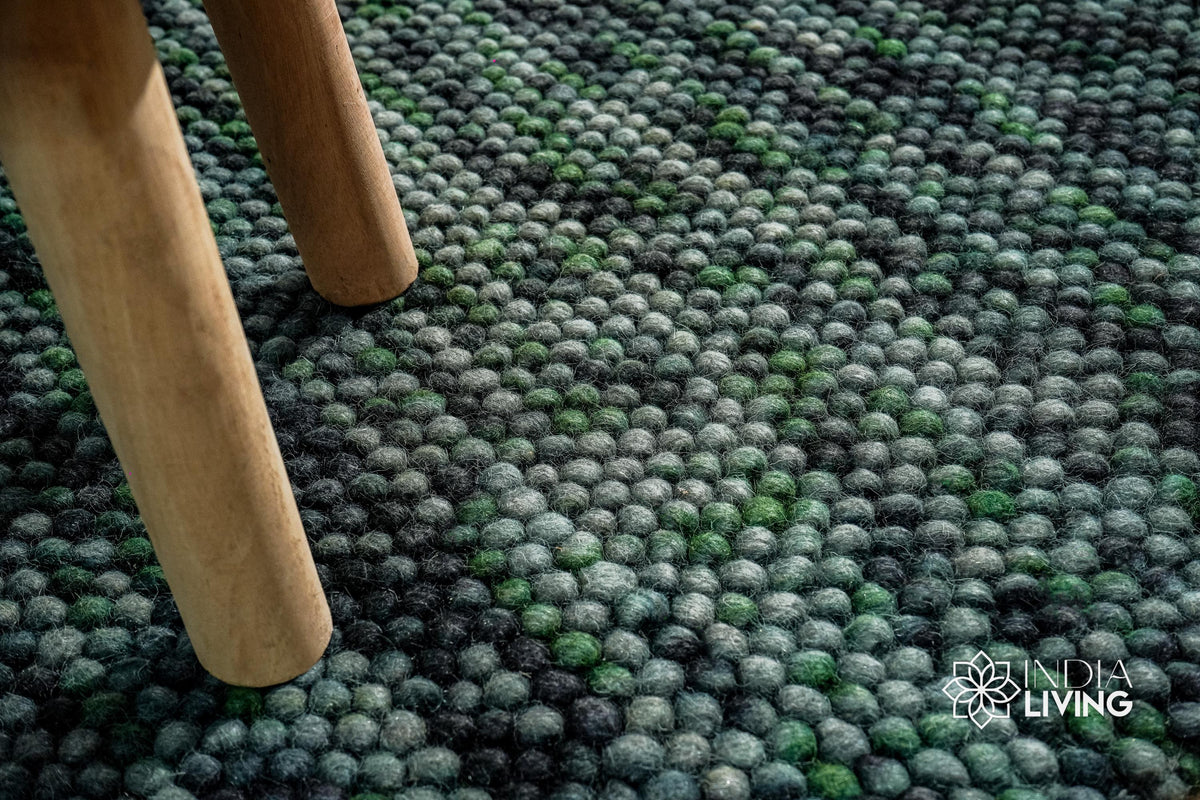Moss green wool rug styled in a living room