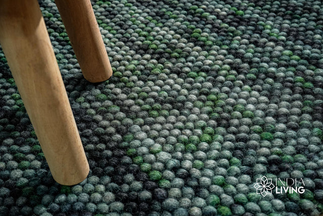 Moss green wool rug styled in a living room