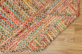 Hand braided rainbow rug shown in a bedroom setting