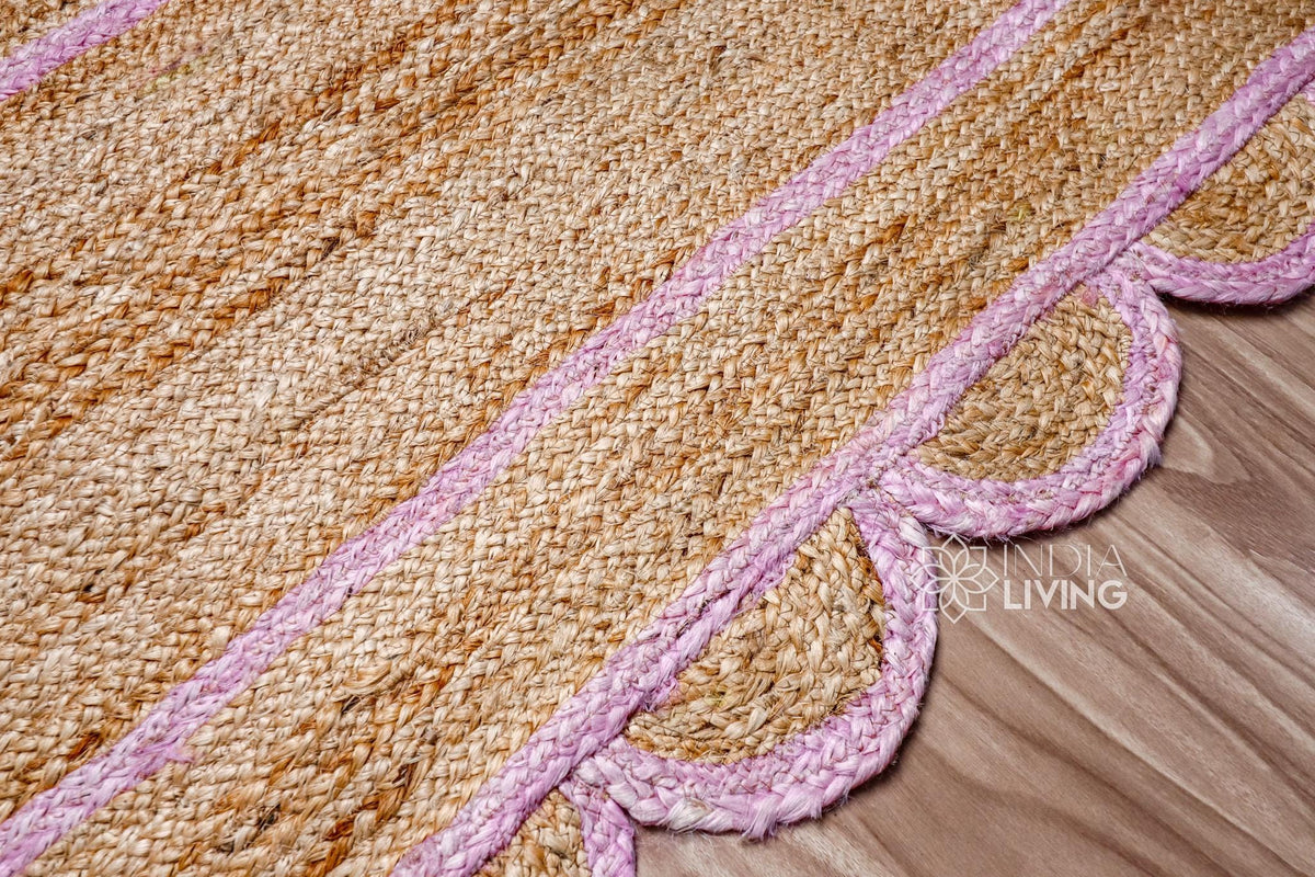 Light pink scalloped jute runner styled beside furniture in a living room