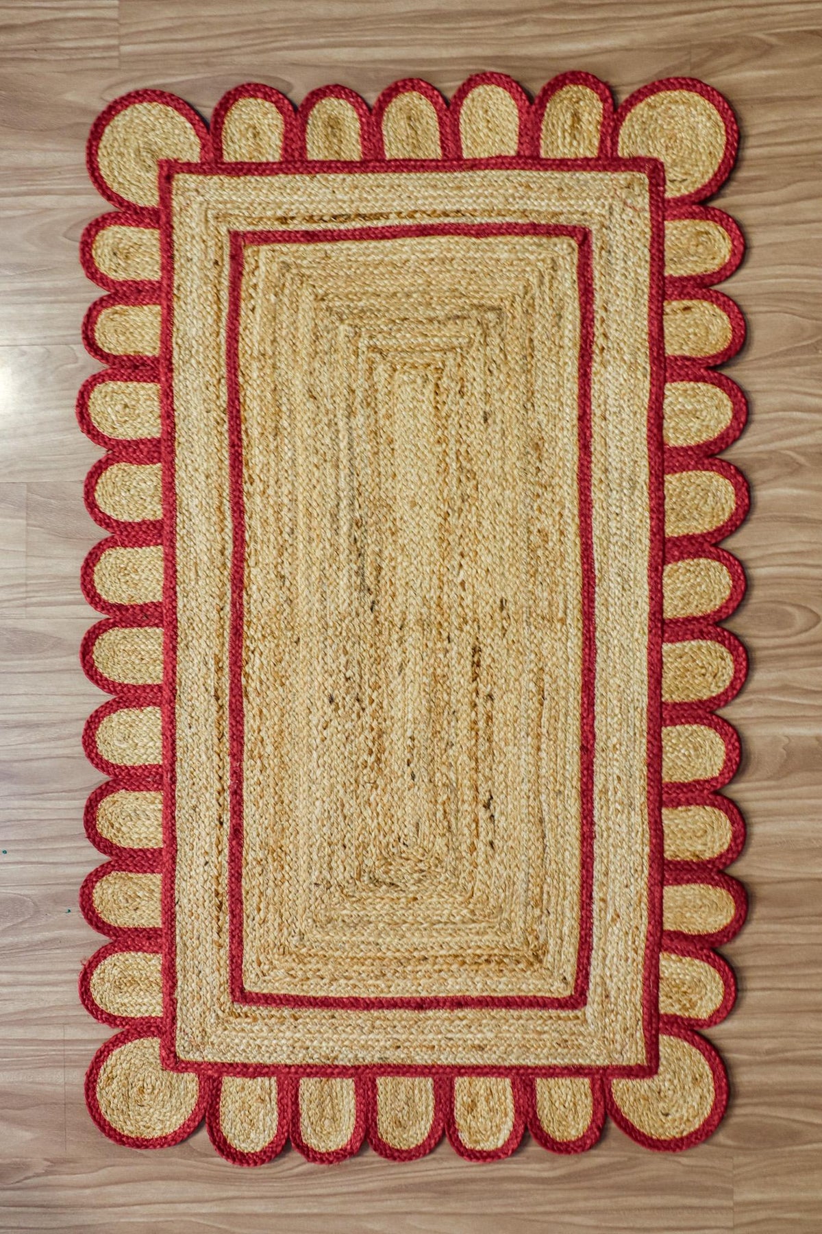 Close-up of scalloped edge detail on red jute runner
