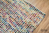 Colourful handwoven wool area rug on a wood floor