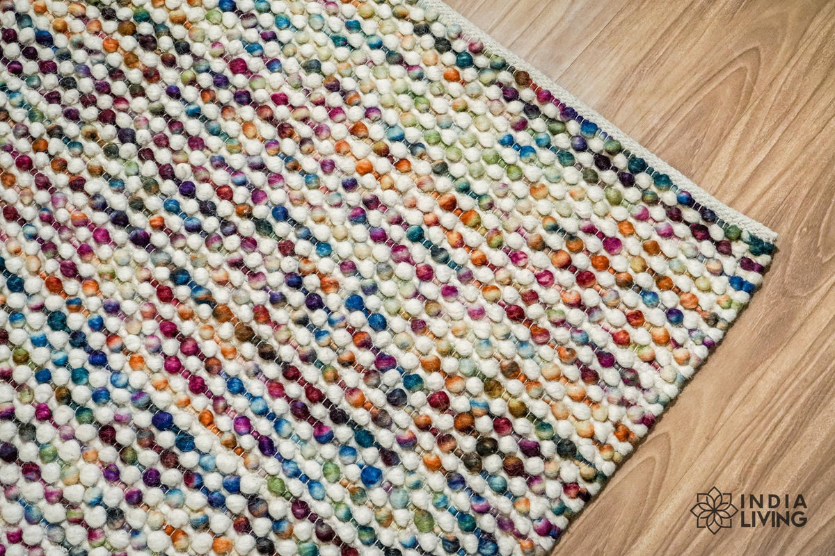 Colourful handwoven wool area rug on a wood floor