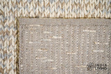 Taupe grey chunky wool rug folded to show thickness and texture
