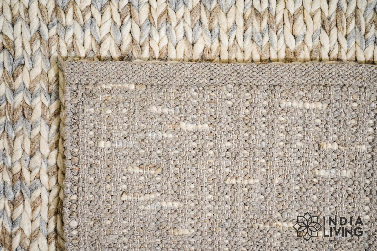Taupe grey chunky wool rug folded to show thickness and texture