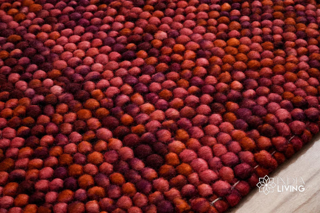 Terracotta red wool rug styled in a living room setting