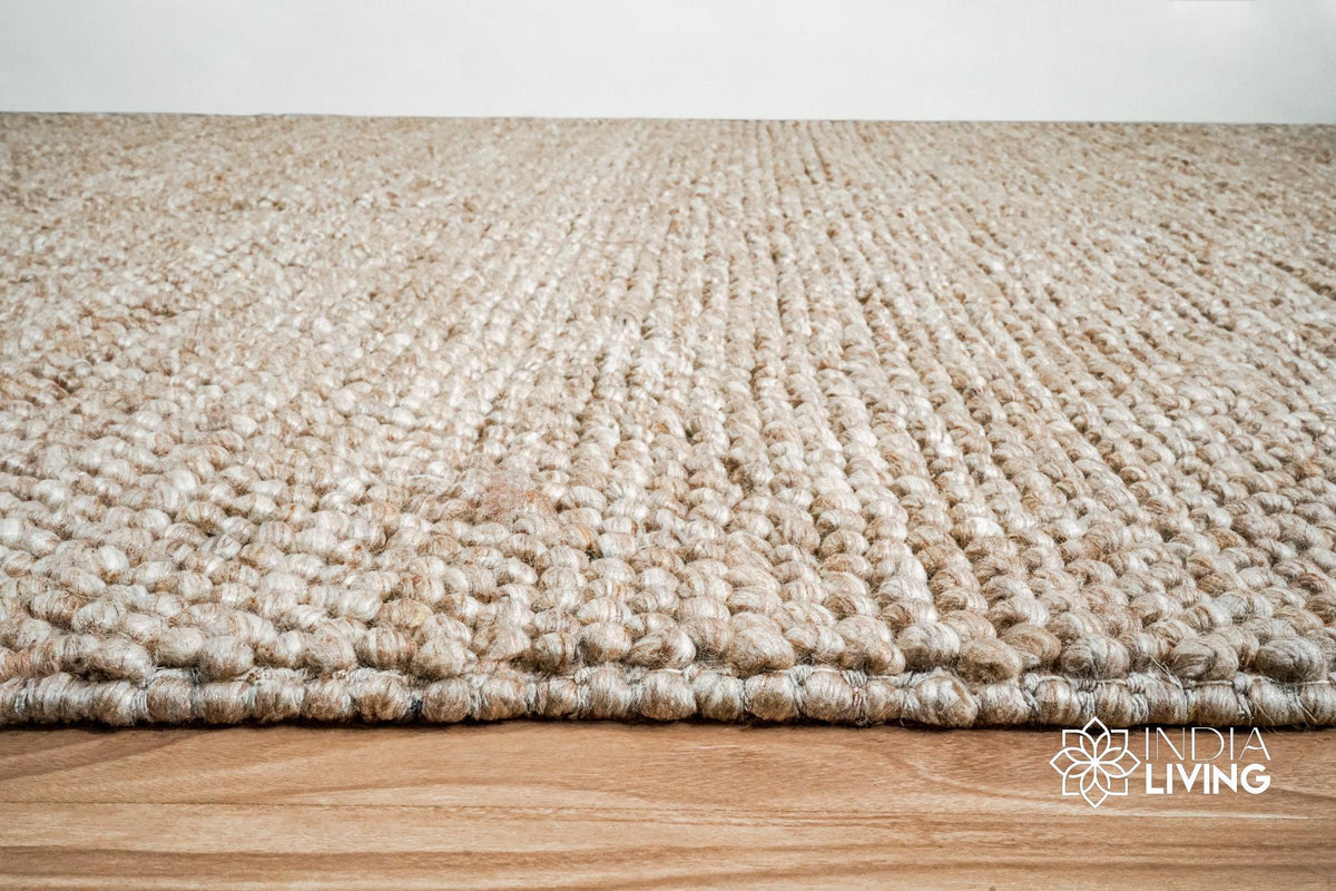 Corner view of beige chunky wool rug showing thickness