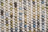 Full view of pastel chunky wool rug on wood floor