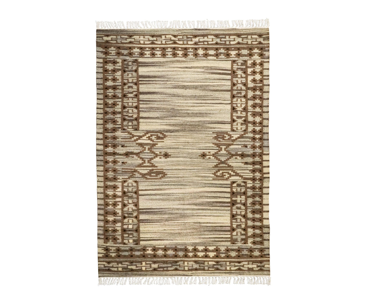 Beige wool kilim rug folded to show flatweave construction
