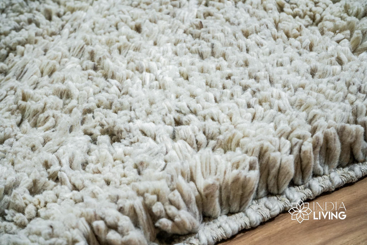 Taupe grey wool shag rug styled in a bedroom setting