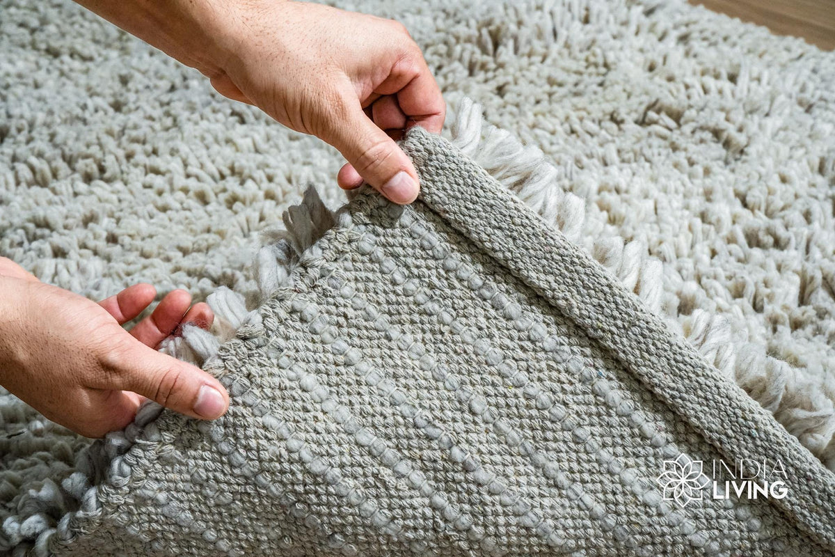 Overhead view of taupe grey wool shag rug on flooring