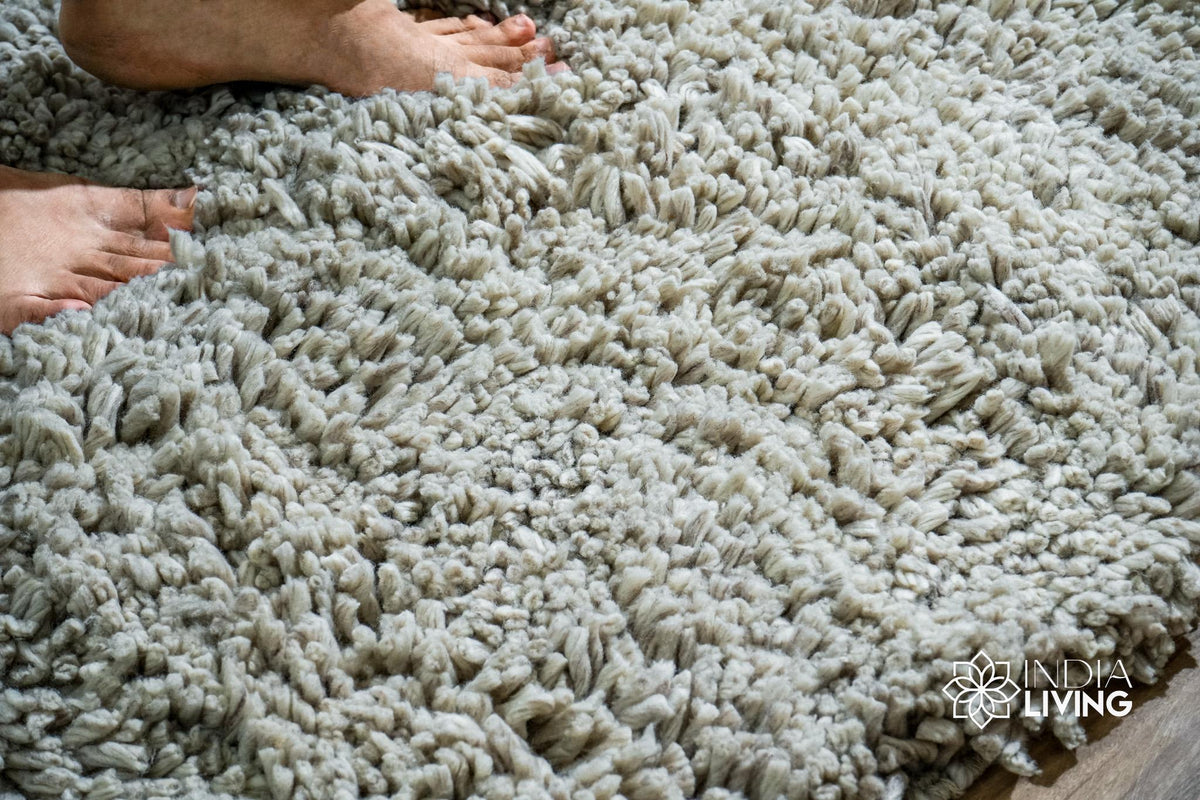 Taupe grey wool shag rug folded to show thickness and texture