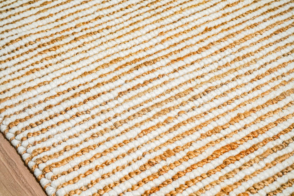 Natural ivory wool jute rug styled in a bedroom setting